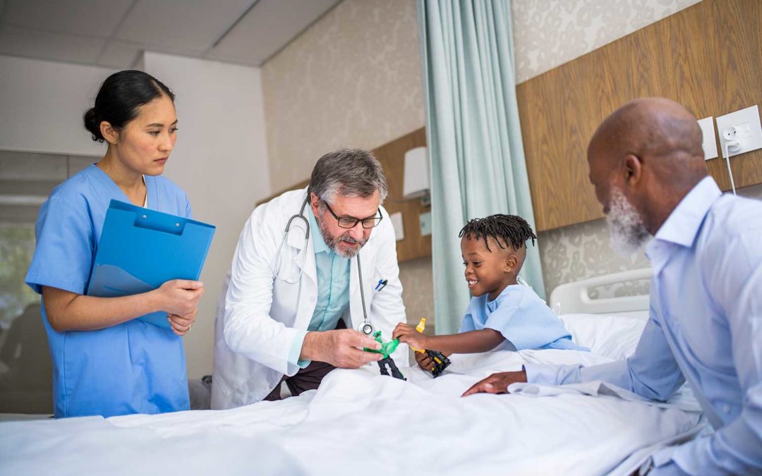A Pediatrician and PA meet with a hospitalized child and his father.